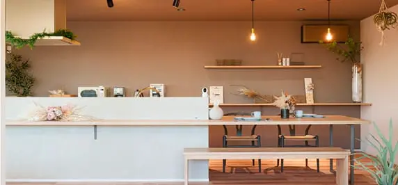 ナチュラルカラーでまとめられた開放感のあるキッチンとダイニングスペース。シンプルながらも温かみのあるインテリアで、照明や植物の装飾がアクセントに。