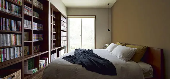 木製とスチールの組み合わせが美しいオープンシェルフに、花瓶やアートブック、ドライフラワーがバランスよくディスプレイされ、洗練されたインテリアの一部となっている。